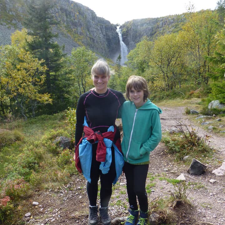 En kvinna och ett barn med ett vattenfall i bakgrunden.